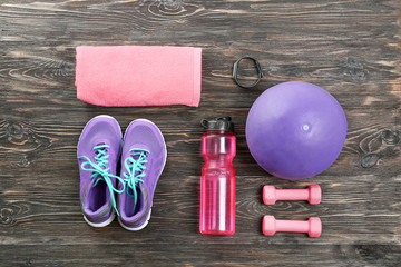 Composition with towel and sport equipment on wooden background