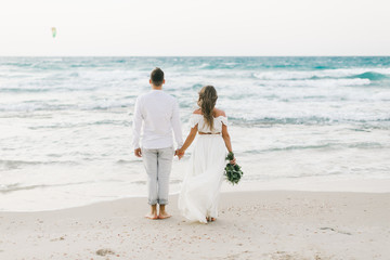 A loving couple is walking on the beach