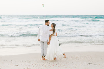 A loving couple is walking on the beach
