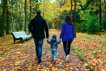 family with child walking in city park
