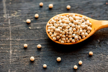 White peppercorn in wooden spoon studio shot
