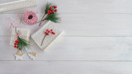 Accessories for packaging Christmas gift ,fir tree branch with red, wrapping paper, roll of Red and white thread , xmas candy  and different wrap presents. Copy space.