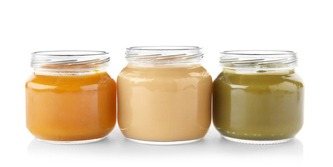Glass jars with nutrient baby food on white background