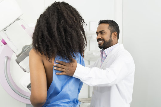 Doctor Assisting Young Woman Undergoing Mammogram Test