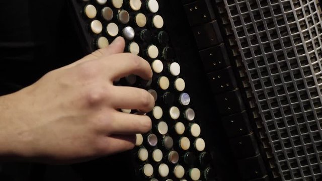 Playing on a big accordion. Playing the harmonica close-up. Old musical instrument Russian bayan - button accordion close-up