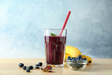 Glass with acai juice and berries on wooden table