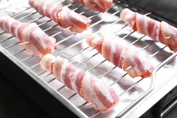 Bacon wrapped chicken nuggets on baking rack, closeup