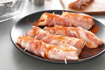 Plate with bacon wrapped chicken nuggets on table