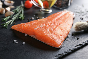 Slate plate with salmon fillet on table