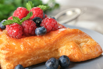 Delicious pastry with berries on plate, closeup