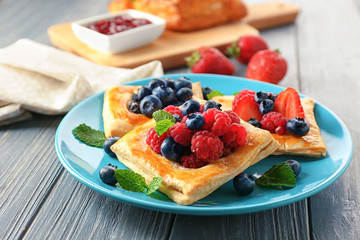 Plate with delicious pastry on wooden table