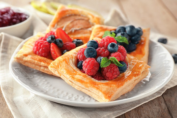 Plate with delicious pastry on table