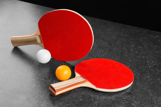 Ping pong rackets and balls on grey table