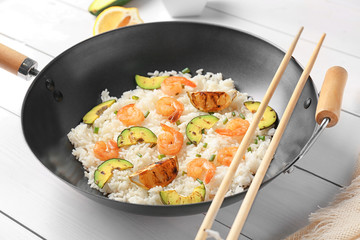 Frying pan with delicious shrimp fried rice on table