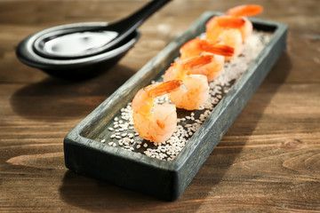 Plate with delicious grilled shrimps on wooden table