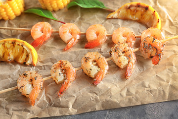 Skewers with delicious grilled shrimps on table