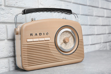 Retro radio on table near brick wall