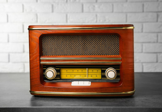 Retro radio on table near brick wall