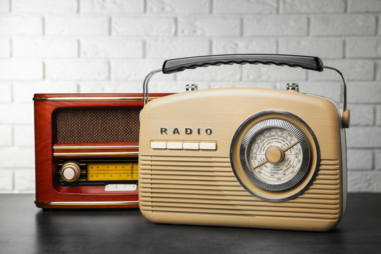 Retro radios on table near brick wall