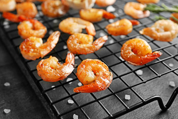 Cooling rack with delicious grilled shrimps on table
