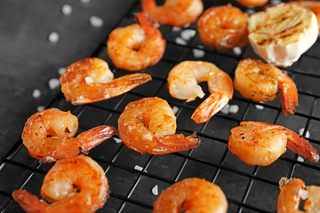 Cooling rack with delicious grilled shrimps on table