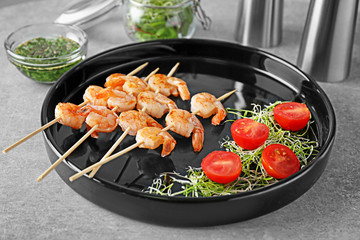 Skewers with delicious grilled shrimps on plate