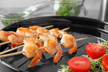 Skewers with delicious grilled shrimps on plate