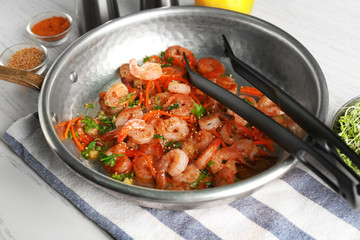 Frying pan with delicious grilled shrimps on table
