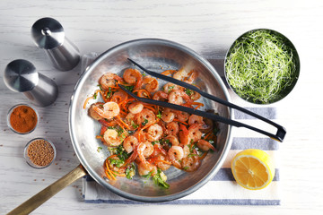 Frying pan with delicious grilled shrimps on table