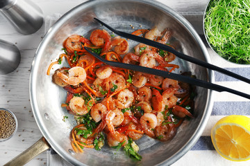 Frying pan with delicious grilled shrimps on table