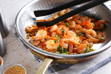 Frying pan with delicious grilled shrimps on table