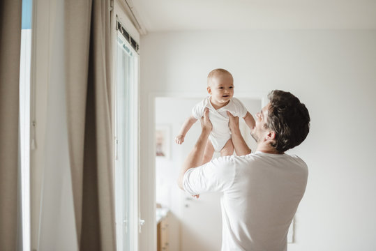 Father holding baby girl at home