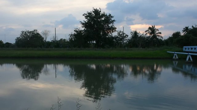 Motion and wave water in canal watercourse waterway of water supply with water pipe at countryside while sunset time in Nonthaburi, Thailand