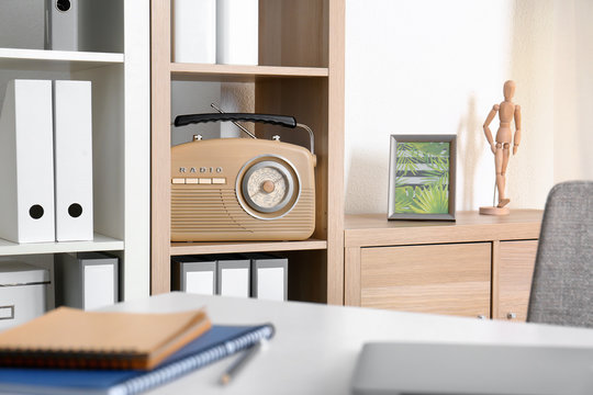 Modern radio on shelf in room