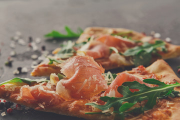 Pizza with prosciutto and rocket salad copy space