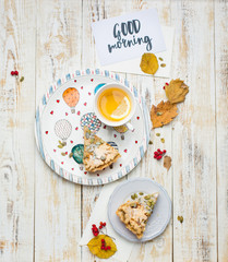 Autumn background with pumpkin pie, hot tea, yellowed leaves, book and rug. Perfect sunny autumn. A wooden light white autumn background for you. Copy Space. Place for text. Flat lay, top view