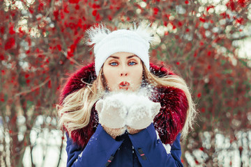 woman blowing snow in hands