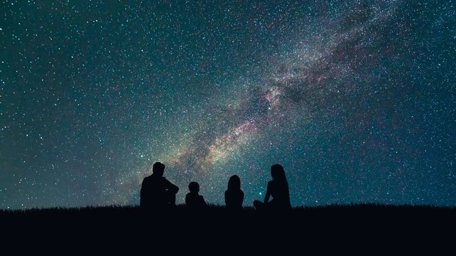 The family sit on stars fall background. night time, time lapse