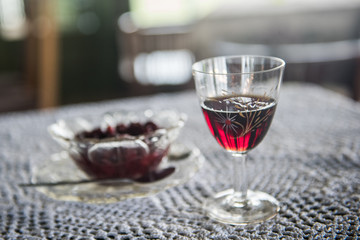 Cranbery snaps in a crystal glass on a table with cranberries in a jar in the background