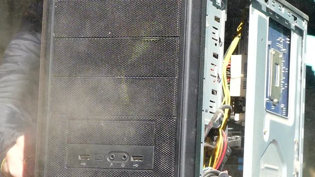 Man technician blows the computer from dust