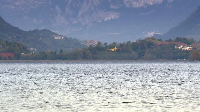Pusiano, Italy - October 2017: Firefighting aircraft Canadair refilling from the lake during the fire emergency in the mountains near Como