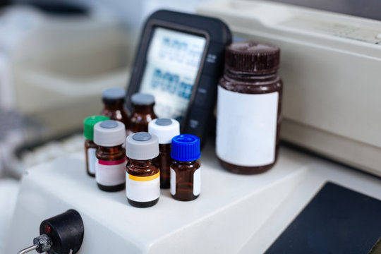 Never mix up. Several different size vials gathered together with digital panel located on the background waiting to heal you