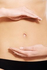 Close up on female's belly with hands.