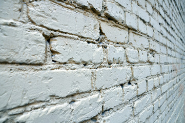 old brick wall as background or texture white grey sometimes scaly cracked paint