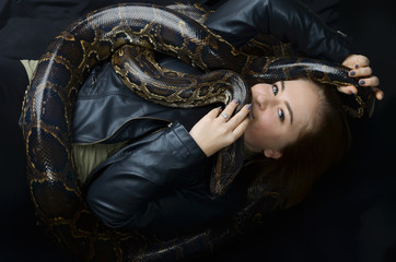 beautiful portrait yong girl and giant snake in the studio