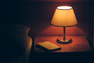 Vintage lamp on night table in hotel room
