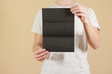 Man showing blank black flyer brochure. Detailed booklet. Leaflet presentation. Pamphlet hold...