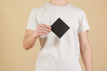 Man showing blank black square flyer brochure booklet. Leaflet presentation. Pamphlet hold hands....