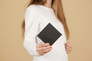 Girl showing blank black square flyer brochure booklet. Leaflet presentation. Pamphlet hold hands....