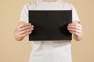 Man holding black A4 paper horizontally. Leaflet presentation. Pamphlet hold hands. Man show clear offset paper. Sheet template. Booklet design sheet display read first person